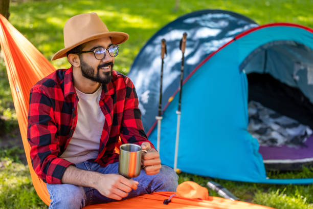 istock Bearded young man in s straw hat feeling relaxed in hammock 1607474972