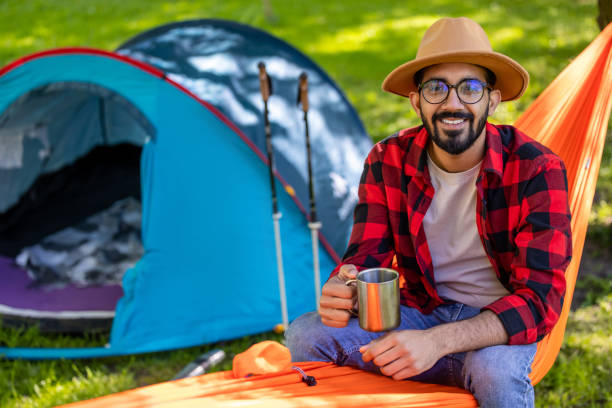 istock Bearded young man in s straw hat feeling relaxed in hammock 1607474979