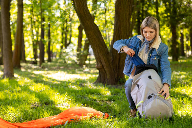 istock Blonde young woman unpacking a backpack in a forest 1607476756