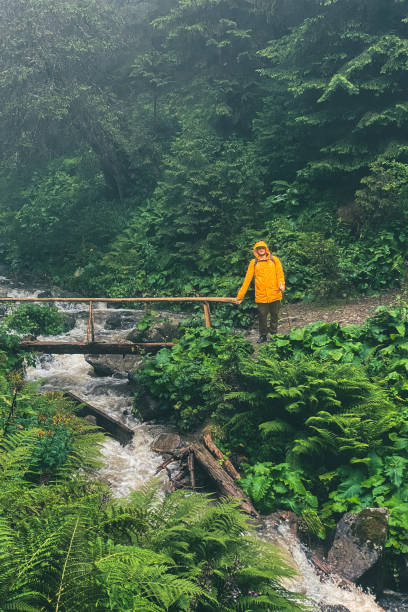 istock man in yellow raincoat at mountain trail 1607478892