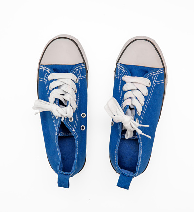 Sneakers, blue color canvas pair of shoes isolated on white, top view