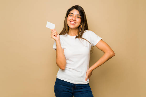 istock Hispanic woman smiling using a blank credit card 1607498155