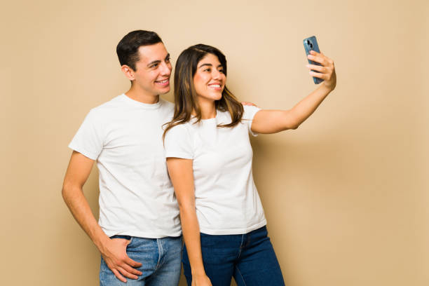 istock Attractive couple taking a selfie wearing matching t-shirts 1607499189