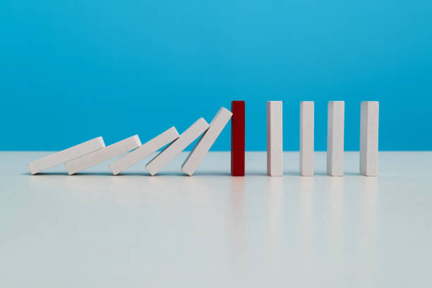 istock Red wooden block stop other falling dominos 1607507687