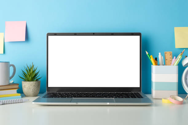istock Explore the online learning environment with a side view image of a white desk, laptop, small cactus and stationery against an isolated blue background, allowing for text or advertising integration 1607541489