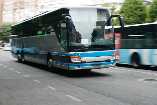 A coach bus in motion in a city