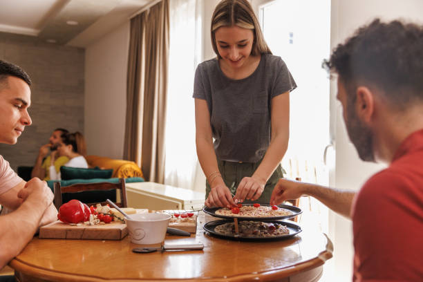 istock Small group of friends making a pizza together 1607605617