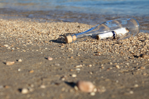 Bottle with a SOS message aground on a sandy beach