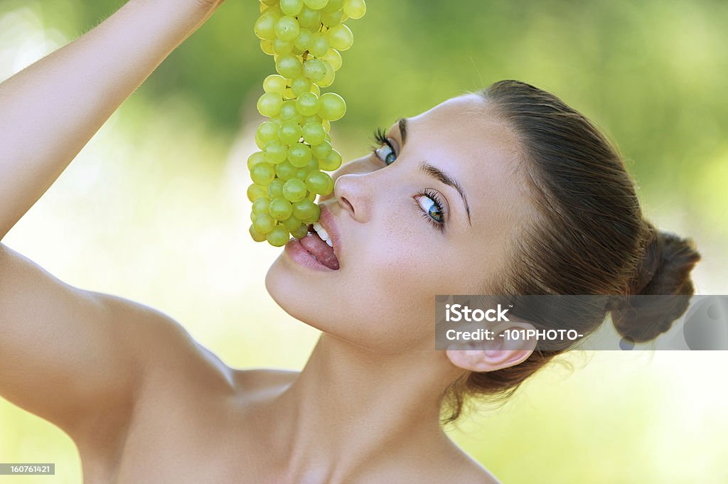 Kobieta przekąski z grona z winogron - Zbiór zdjęć royalty-free (Dorosły)