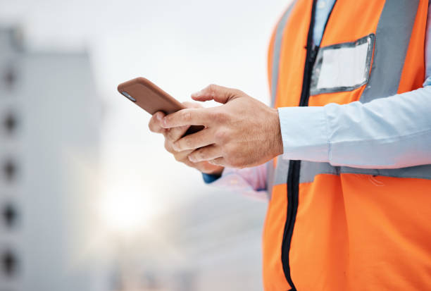 istock Phone, engineering and hands of man in city for architecture, construction site and communication. Building, social media and mobile app with closeup of contractor for contact, networking and mockup 1607631960