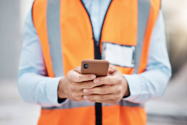 istock Phone, construction site and search with hands of person for engineering, architecture and communication. Building, social media and mobile app with closeup of contractor for contact and networking 1607631966