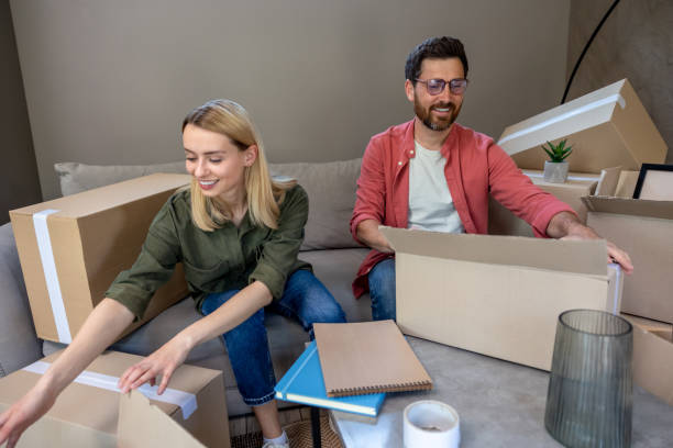 istock Young family looking involved while packing boxes for the move 1607643290