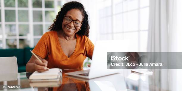 Happy Senior Woman Drafting Her Last Will And Testament In Her Journal Stock Photo - Download Image Now