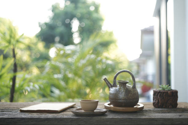 istock Traditional Earthenware teapot and tea cup and notebooks on wooden table 1607680566
