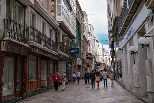 Beautiful and historic city center of A Coruna. People on the streets enjoying time outside at shopping, restaurants and bars. Travel destination in Galicia, Spain.