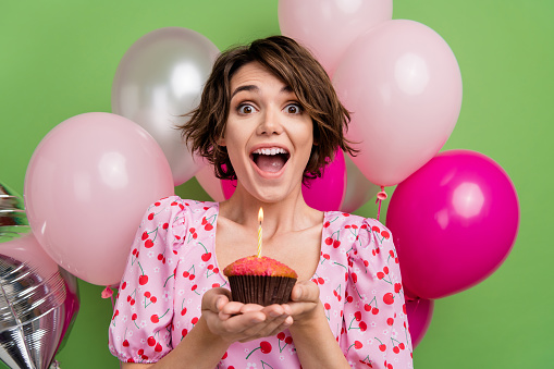 istock Photo of impressed funky lady wear pink blouse wishing dream celebrating birthday isolated green color background 1607687542