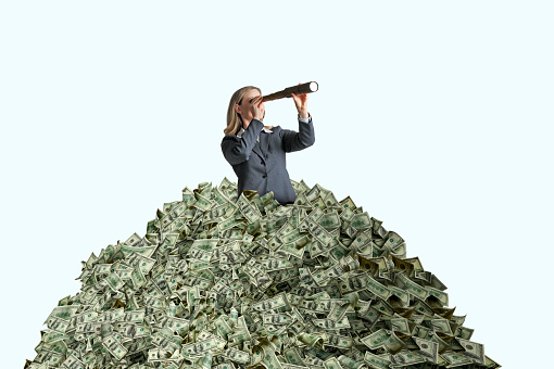 A  woman who is  buried in a pile of cash looks through a spyglass.