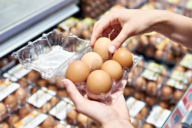 istock Woman with packing eggs in shop 1607725367