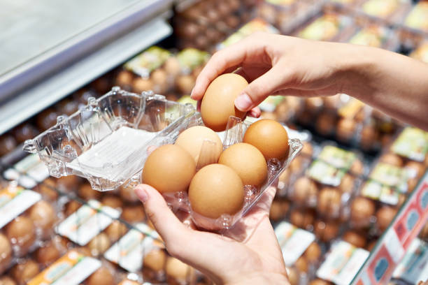 istock Woman with packing eggs in shop 1607725406