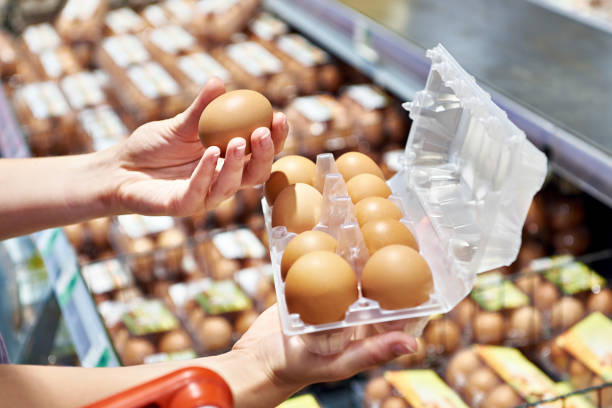istock Woman with packing eggs in shop 1607725952