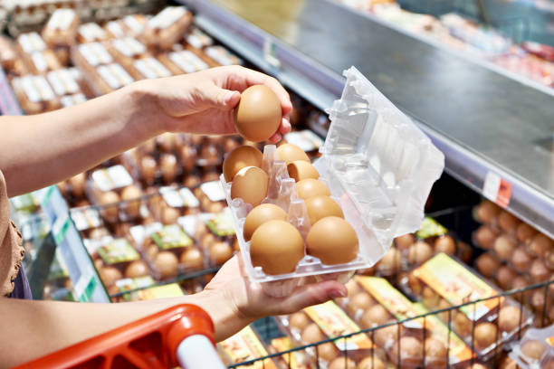 istock Woman with packing eggs in shop 1607726368