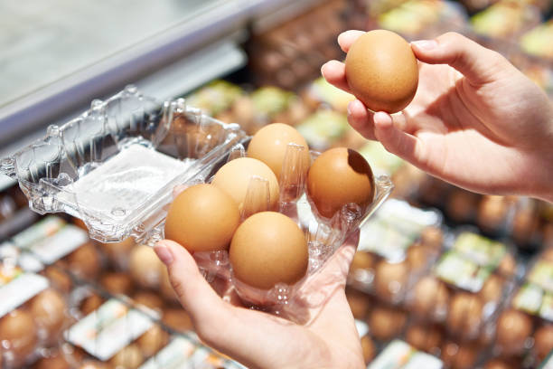 istock Woman with packing eggs in shop 1607727578