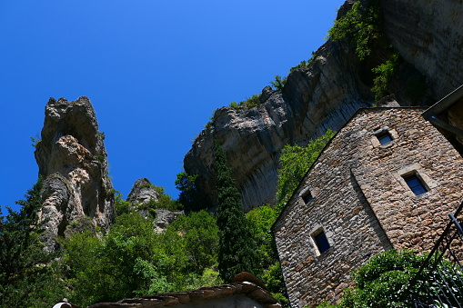 The houses of Pougnadoires below the rocky escarpments in the Gorges du Tarn, Lozère
