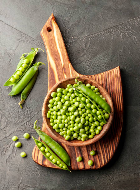 istock Pods green peas on wooden backgrounds. 1607770709