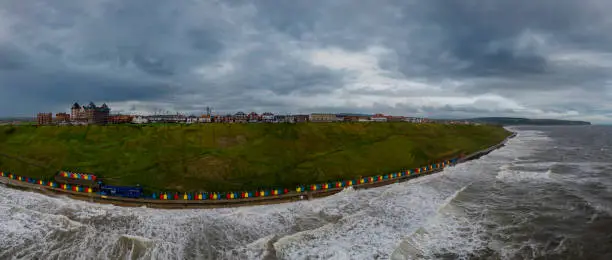 Photo of An aerial view of the colourful beach huts along the sea front in Whitby, North Yorkshire, UK