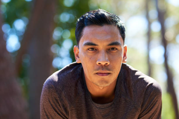 Tired and sweaty Asian man takes a break while trail running, breathing. High quality photo
