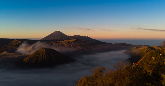 Image of tranquil sunrise in Bromo. The Volcanic mountains formation of Mount Bromo, Mount Batok, and Mount Semeru in East Java, made this place as one of best destination in the world.  Where the sunrise moment is always captivated tourists and the most waited moment of nature attraction.