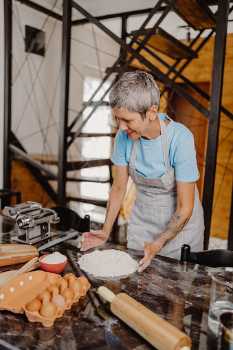 Senior woman preparing homemade pasta at her home