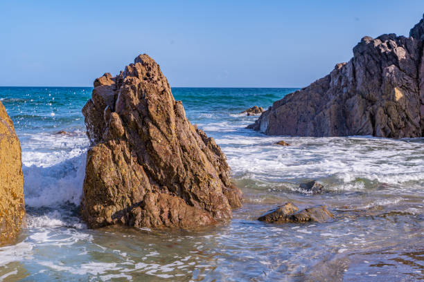 istock Waves crash around a rock on Kennack Sands, Cornwall. 1607812372