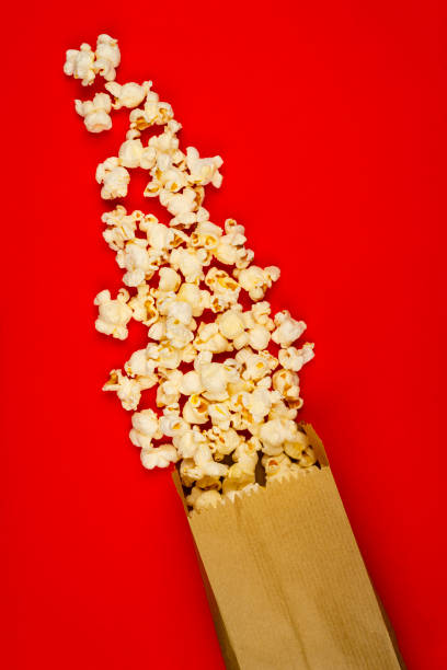 istock Popcorn and paper bag on red background 1607825435