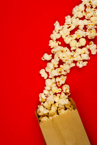 istock Popcorn and paper bag on red background 1607826253