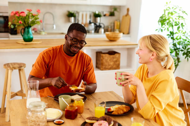 istock Multiracial couple enjoying breakfast together at home 1607839627