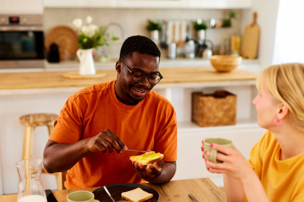 istock Multiracial couple enjoying breakfast together at home 1607841737
