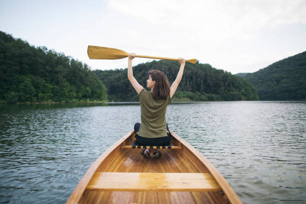 istock Woman holding canoe paddle high 1607848813