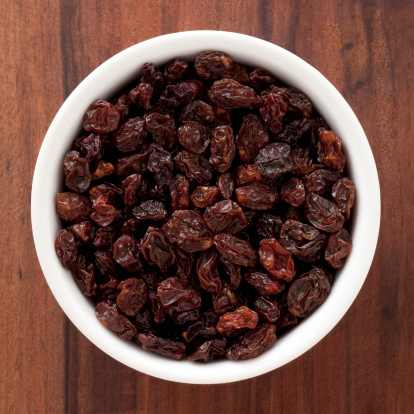 Top view of white bowl full of raisins