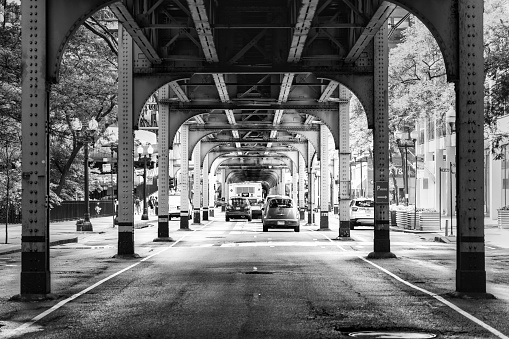 Chicago, Illinois, USA - July 3, 2023: Cars on the street under the train tracks at South Wells Street.