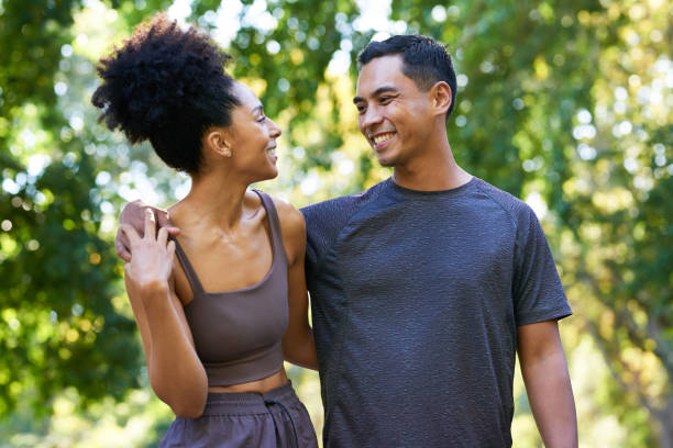 istock Beautiful young multi-ethnic couple exercise together in park, pose and smile 1607880093