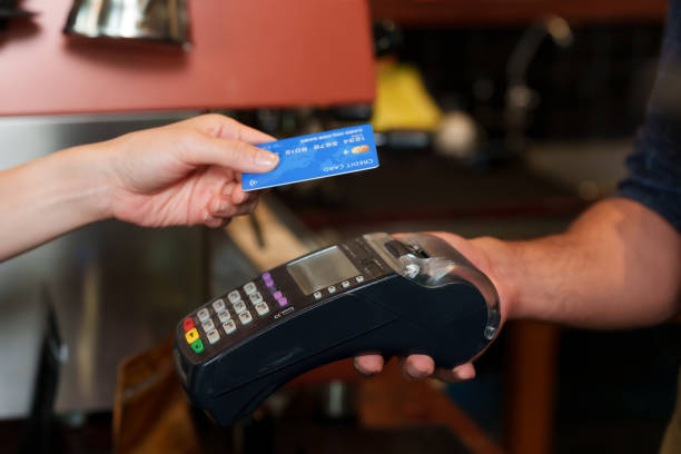 istock Close-up customer hand using credit card with data reading system to pay with a credit card reader for coffee and bakery Minimize contact and no cash payments Not enough cash. In cafe while traveling 1607909396