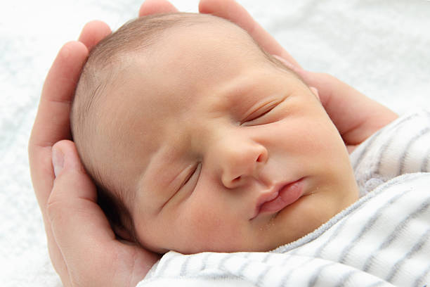 istock Beautiful sleeping baby in hands 160791361