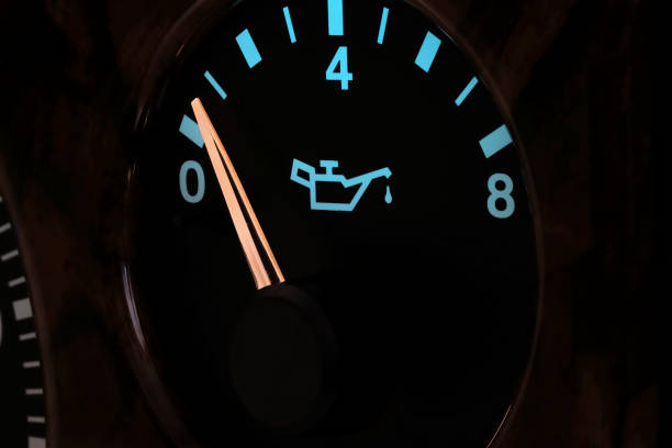 oil pressure gauge in car dashboard in illuminated night mode - low