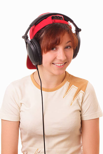 Funny young girl listening to the music with headphones stock photo