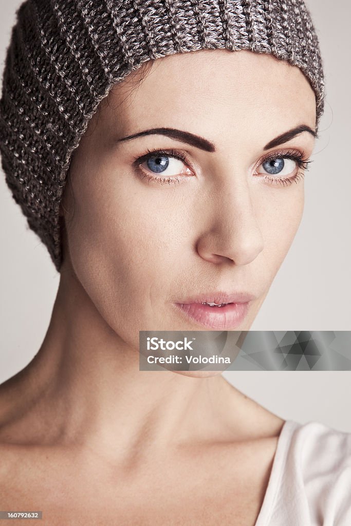 Elegante ragazza in un cappello lavorato a maglia - Foto stock royalty-free di Abiti pesanti