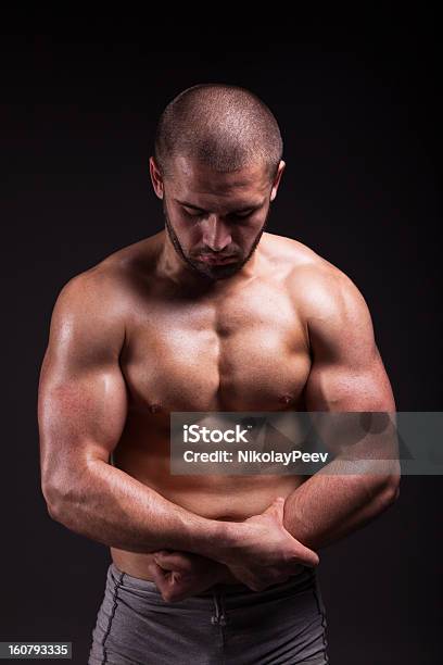 Muscular Man Showing Músculos Aislado Sobre Fondo Negro Foto de stock y más banco de imágenes de Adulto