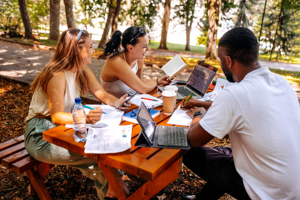 istock Group of students learning outside in public park 1607941321