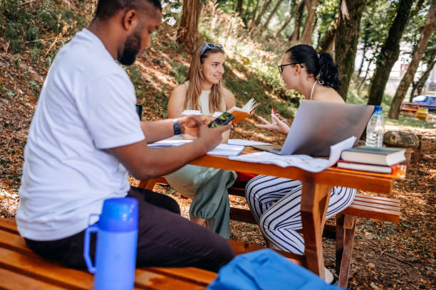 istock Group of students learning outside in public park 1607942964