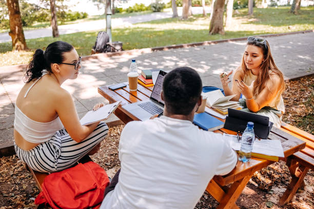 istock Group of students learning outside in public park 1607944157